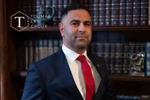 Adam Touma, Greenville criminal defense attorney standing in front of a bookshelf